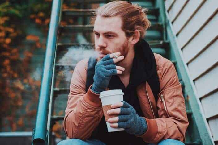 Man smoking while drinking coffee
