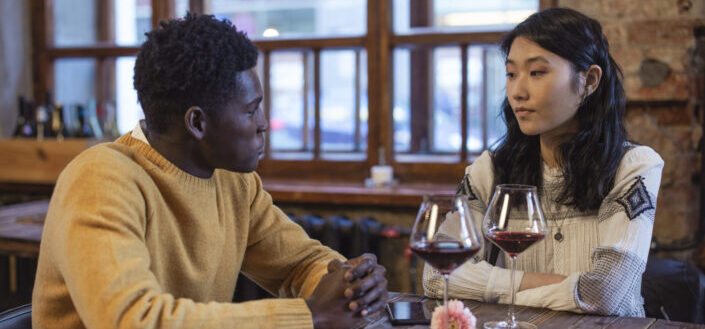 Couple exchanging looks while drinking wine