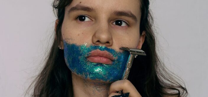 Girl shaving her mustache made of glitters.