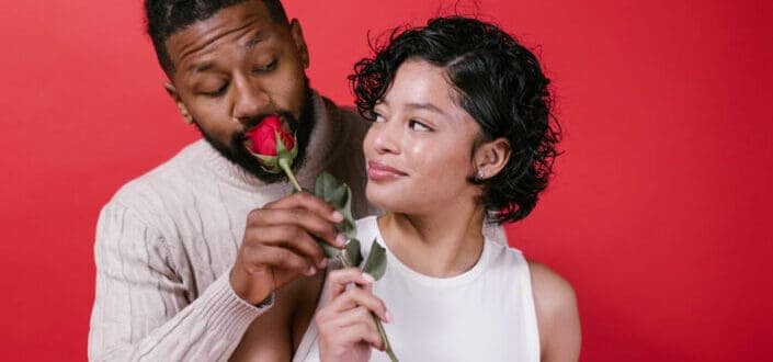 couple holding rose looking at each other 