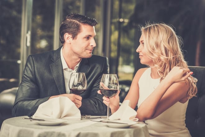 How to Ask A Girl Out - Cheerful couple in a restaurant with glasses of red wine