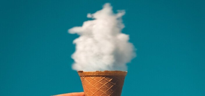 man holding ice cream cone under cloud