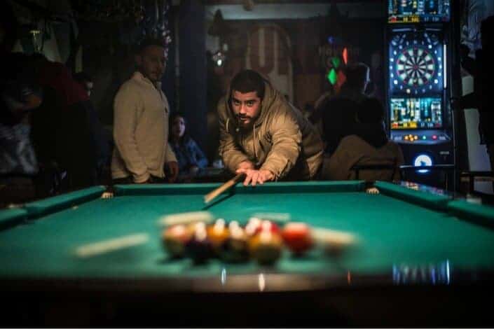 man playing billiard with his friends