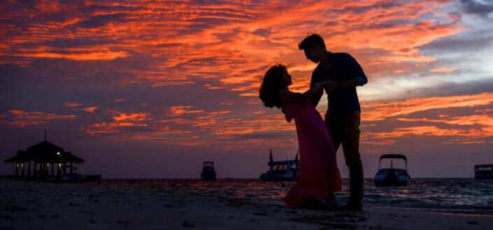 Man and woman on beach during sunset
