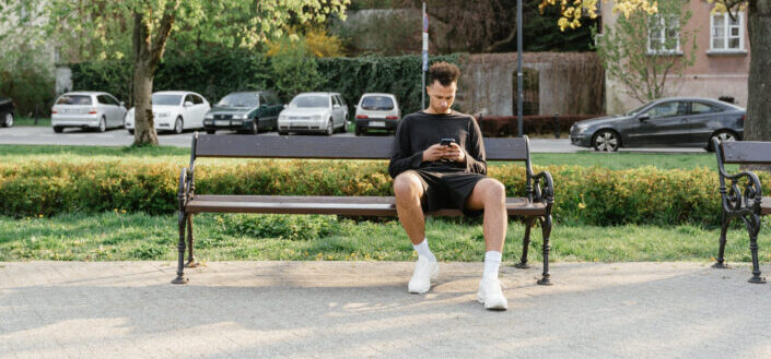Man Wearing Long Sleeve Shirt Sitting on a Park Bench
