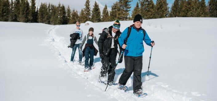 friends trekking through the mountains during snow