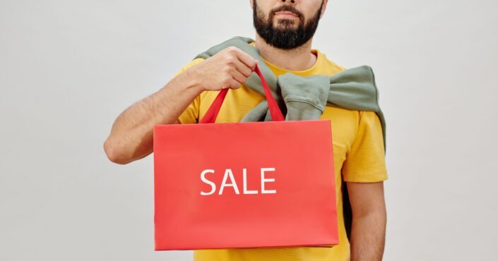 man holding a sale paper bag