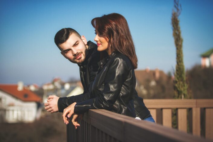 Man staring at his woman while sight seeing from a terrace.