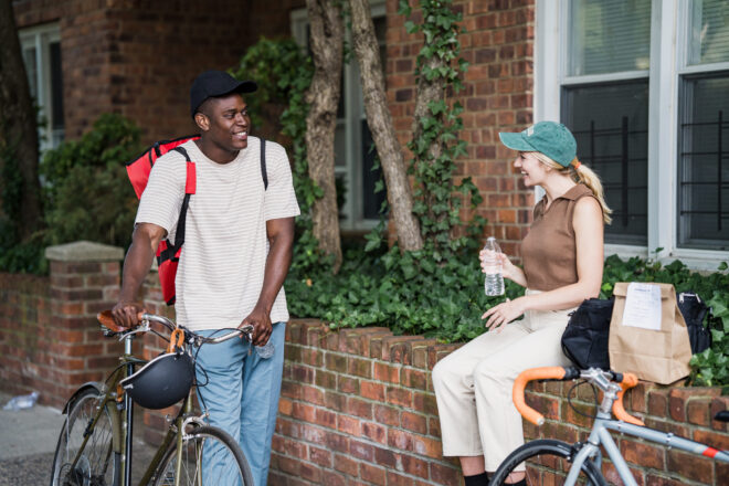 How To Start A Conversation With Your Crush - Man and Woman talking while holding their bikes