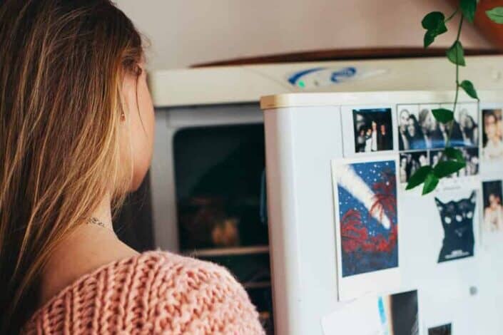 A woman looking inside a refrigerator