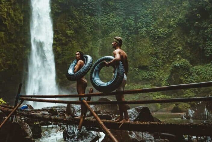 A couple with tires walking towards waterfalls