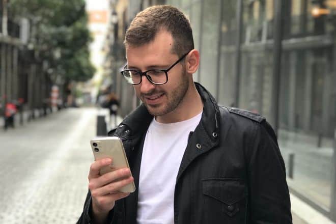 man in black jacket using smartphone - Tinder Conversation Starters