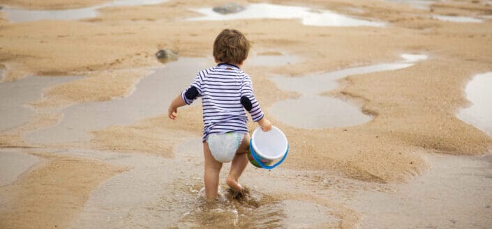 Toddler walking on shoreline