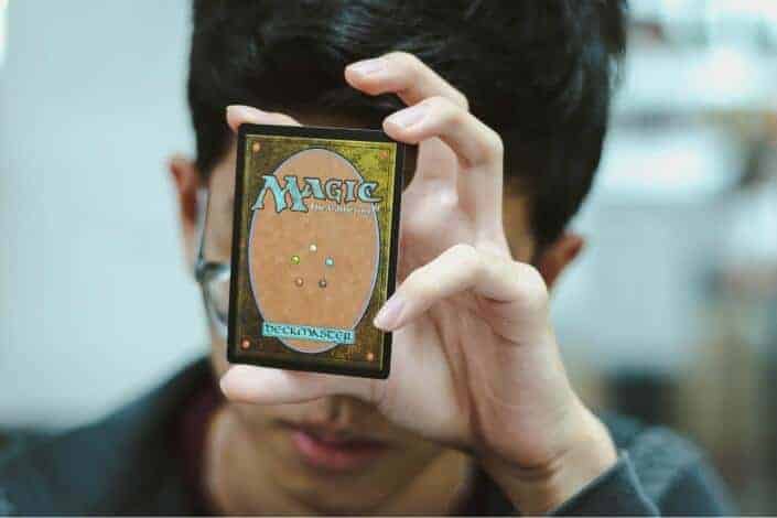 Guy holding a magic card.