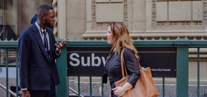 Two people talking by the entrance to the subway station