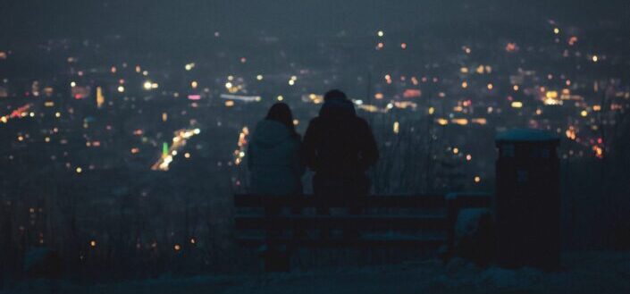 Two persons (a couple?) are having a deep talk at night above the city lights of Stuttgart, Germany