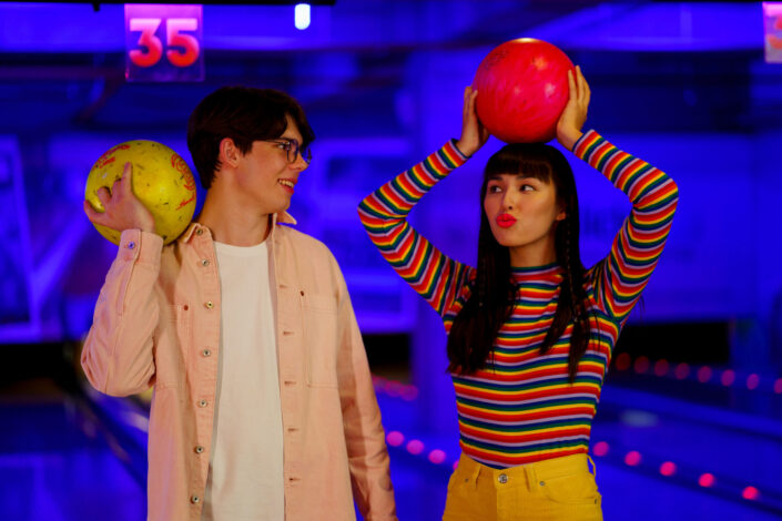 Two young people holding bowling balls
