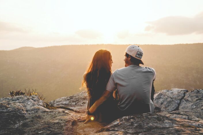 Couple sitting on top of mountain