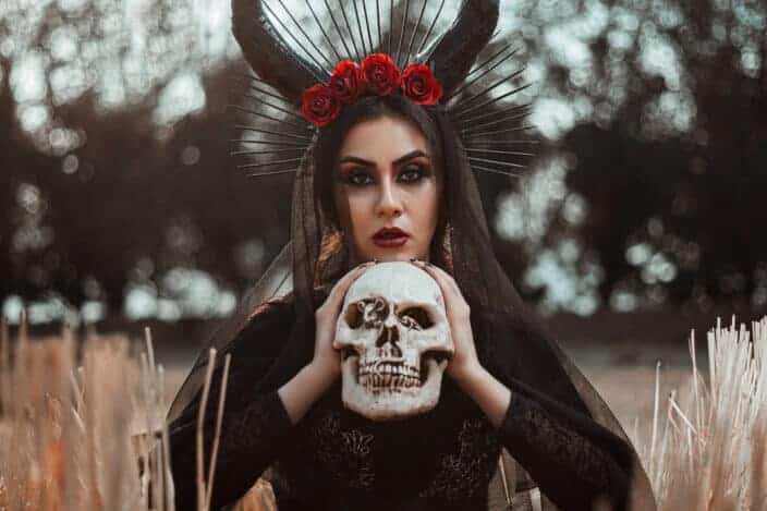 Woman with horns holding a skull