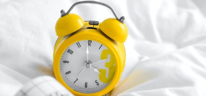 yellow and white analog alarm clock