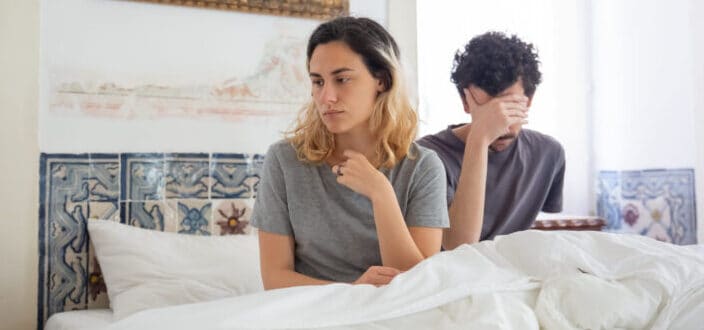 Couple sitting on a bed having some misunderstanding