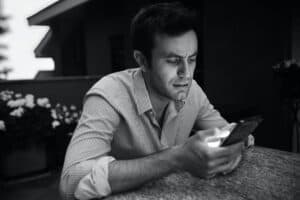 Young man texting in the evening - featured